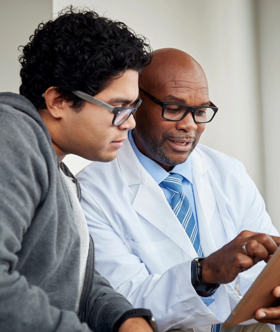 Patient and doctor smiling looking at a tablet