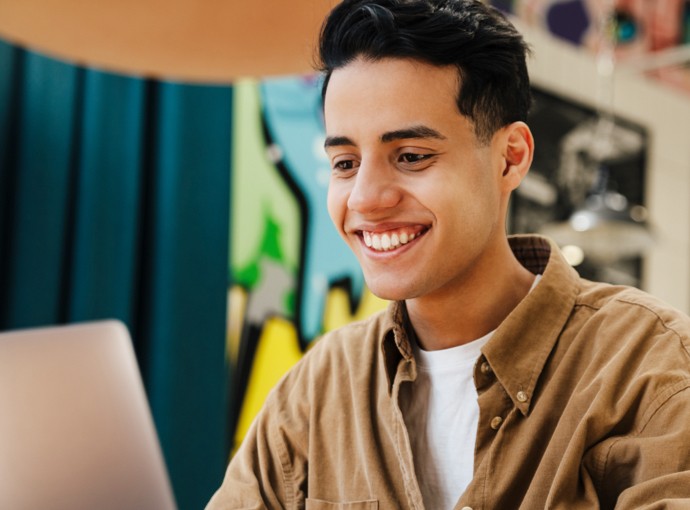 Woman smiling at her phone with headphones around her neck